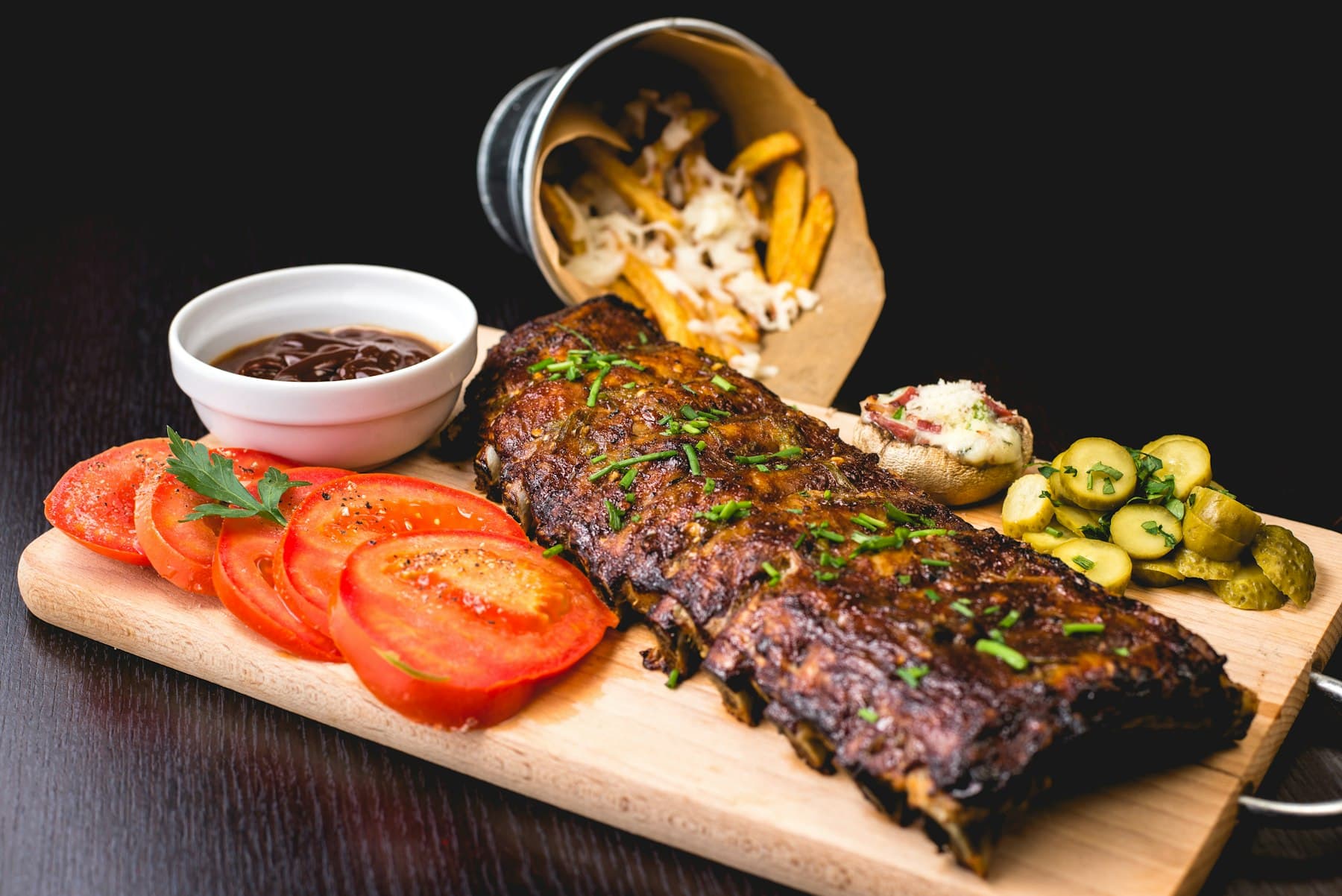 A cut of wood-grilled steak resting over embers